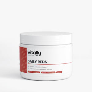 A white plastic jar of Vitally Essential Daily Reds powder supplement with a white lid, featuring a red and black label on a light gray background.
