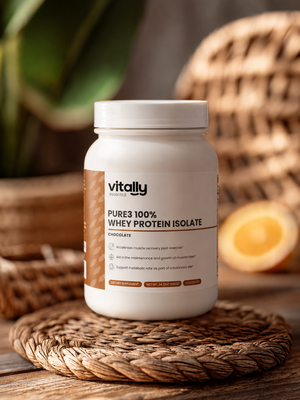 A white tub of Vitally Essential's Pure3 100% Whey Protein Isolate in Chocolate flavor, styled on a woven mat with a wooden table and warm, rustic background elements.